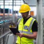 Factory worker using a digital tablet in factory